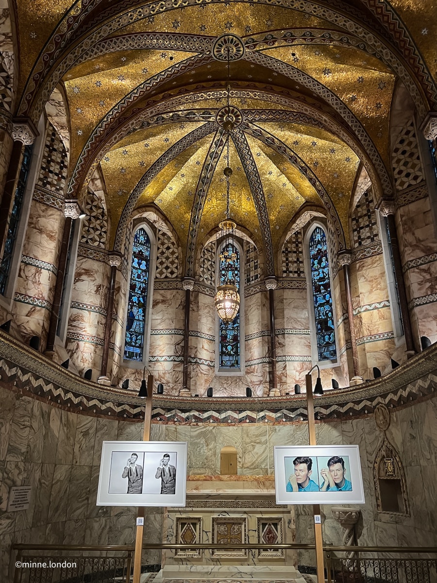 Valokuvien asettelu kappelissa ja alttarin yllä oleva kultainen mosaiikki