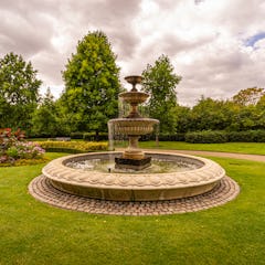 Suihkulähde kukkapenkkien vieressä